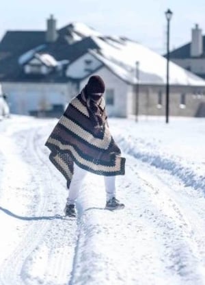 Person outside in the snow wrapped in a blanket